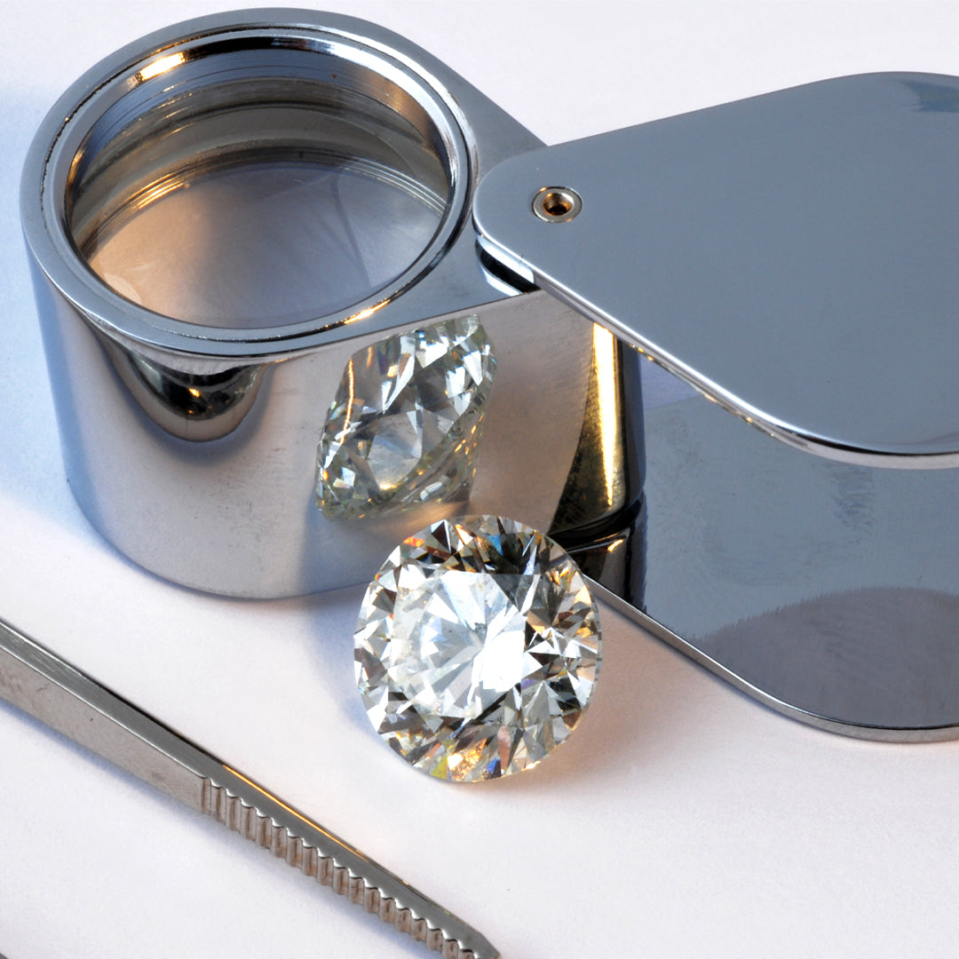 loose round diamond with diamond loupe and tweezers