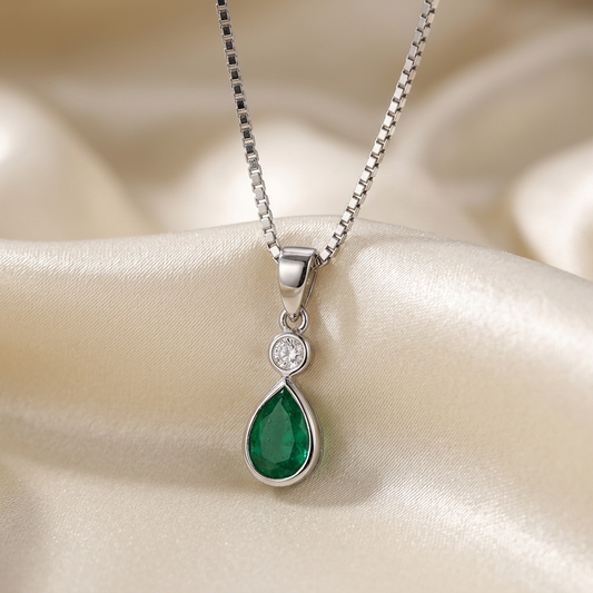 Pear shape bezel set emerald and diamond pendant - angled view