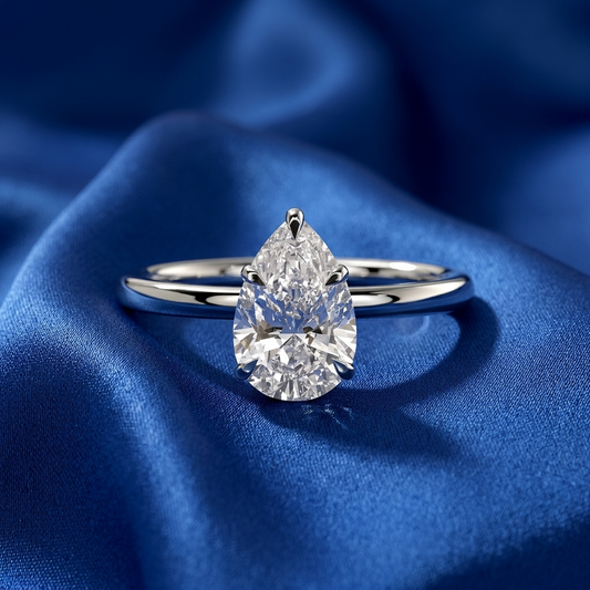 Pear shaped diamond solitaire engagement ring on a fine band