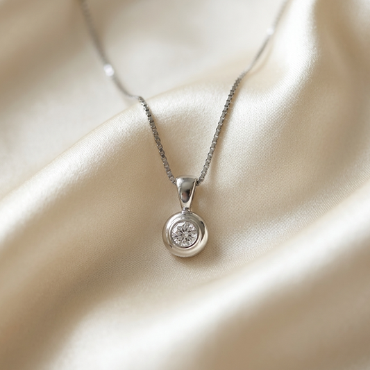 Domed bezel set round diamond pendant in white gold