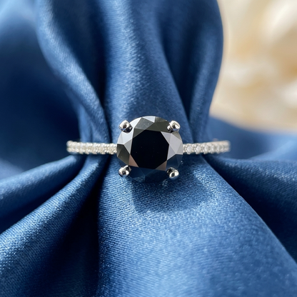 Black diamond solitaire engagement ring with diamond side stones, three quarter view