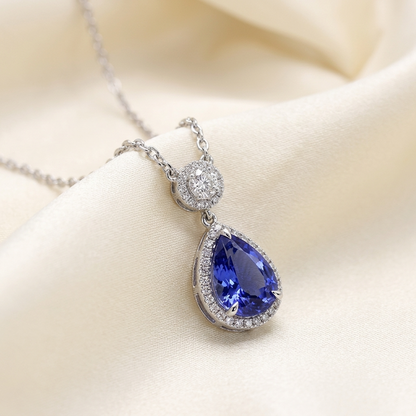 Pear shape tanzanite and diamond halo pendant - angled view