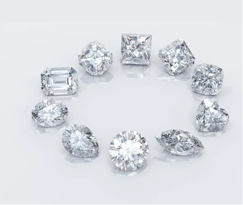 Collection of various cut diamonds on a light gray background